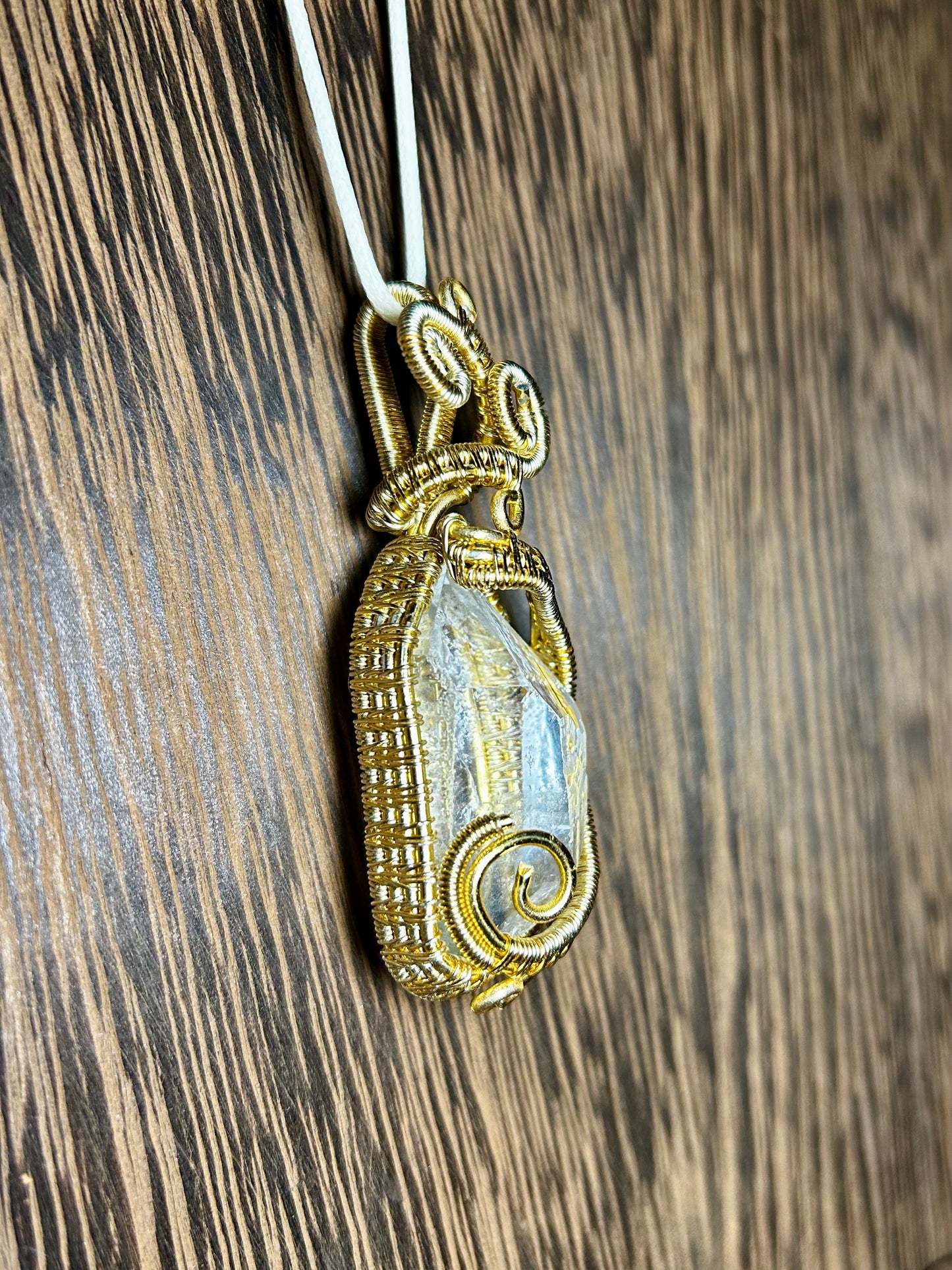 Clear Quartz Wrapped In Gold Colored Wiring