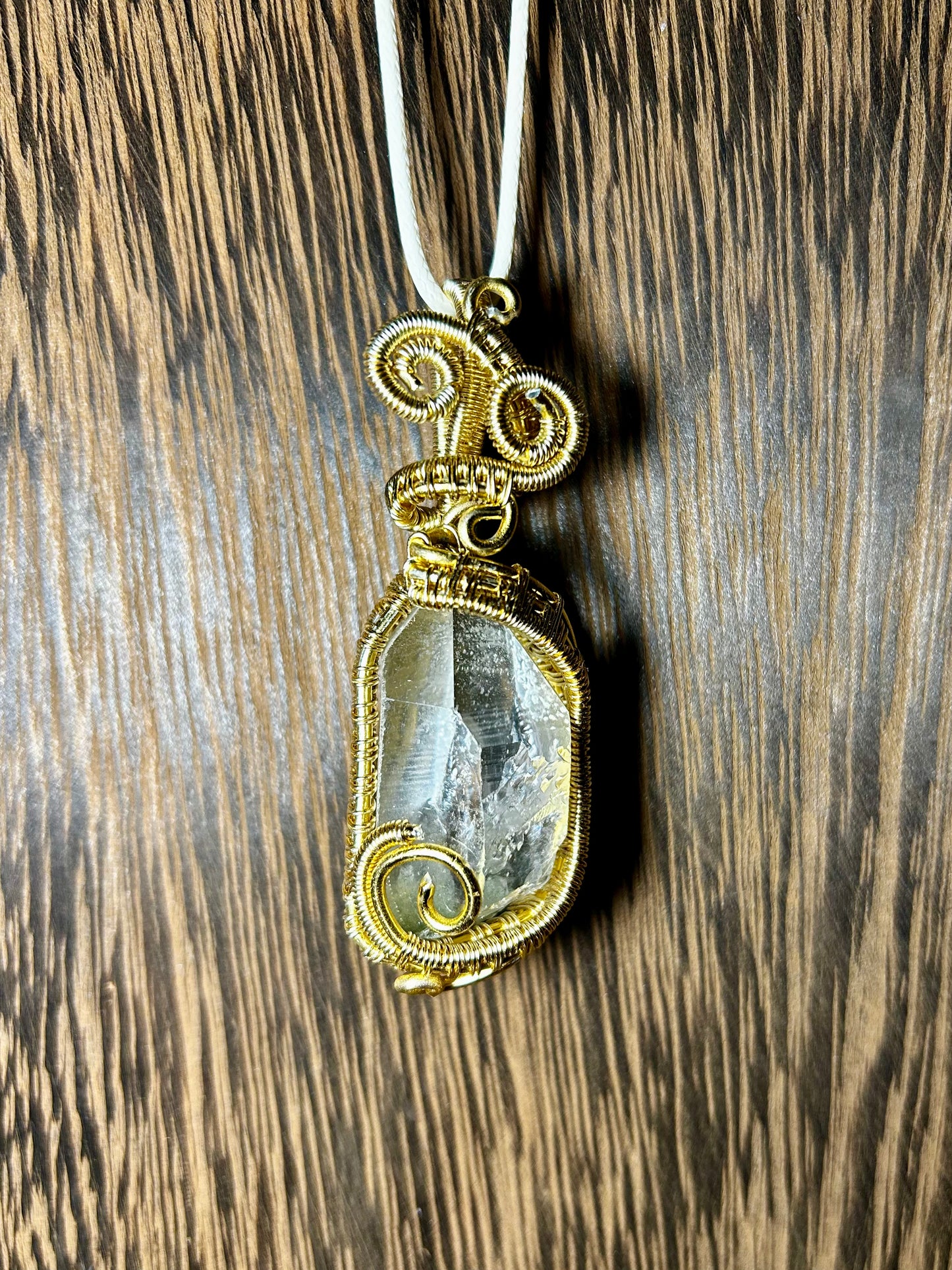 Clear Quartz Wrapped In Gold Colored Wiring